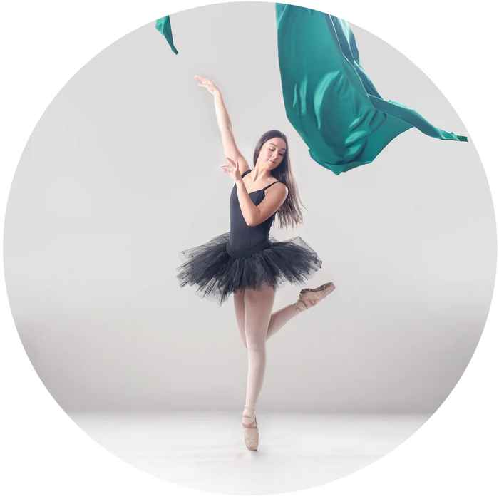 Ballerina in a black tutu posing with teal ribbons on a white background