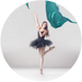 Ballerina in a black tutu posing with teal ribbons on a white background