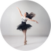 Dancer in a black tutu and white top against a gray background
